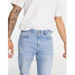 DESIGN tapered carrot jeans in light wash blue with knee rips